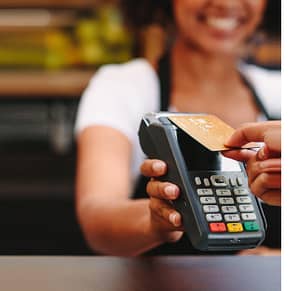 Image of woman holding a credit card terminal